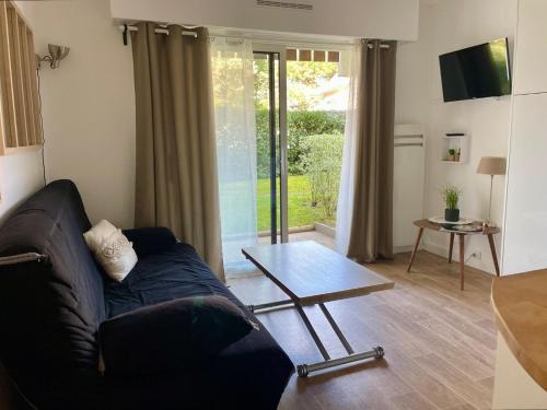 un salon avec un canapé et une table basse dans l'établissement T2 avec terrasse proche de la plage de Royan dans le Quartier du Parc, à Royan