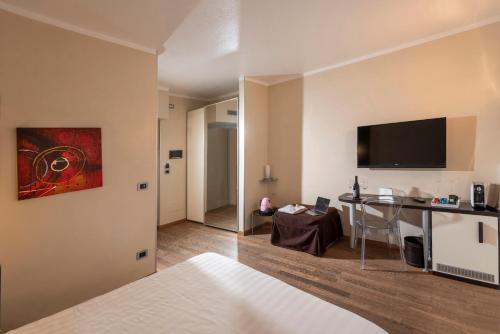 a room with a bed and a table and a television at Casa Boffa in Barbaresco
