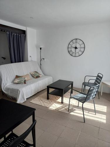 - une chambre avec un lit, une chaise et un réveil dans l'établissement Large studio near medieval city, à Carcassonne