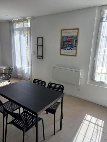 une salle à manger avec une table et des chaises noires dans l'établissement Large studio near medieval city, à Carcassonne