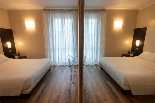 a hotel room with two beds and a window at Casa Boffa in Barbaresco
