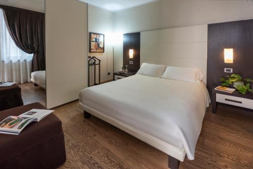 a hotel room with a large white bed and a couch at Casa Boffa in Barbaresco