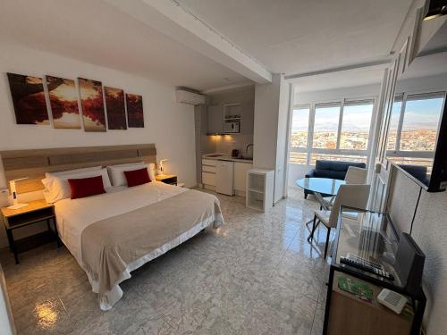 a bedroom with a large bed and a living room at Luceros 310 New in Alicante