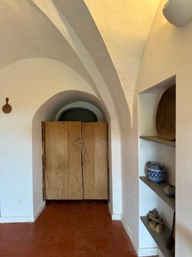 a hallway with a wooden door in a room at Al Palazzotto in Pantelleria