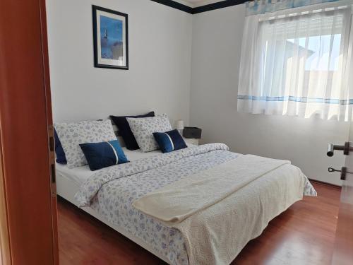 a bedroom with a bed with blue pillows at Lux Villa in Rijeka