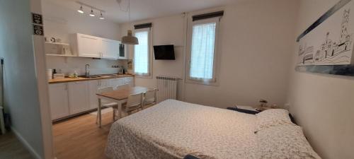 a small bedroom with a bed and a kitchen at Casa Carlotta al Portello, vicino al centro e all'ospedale in Padova