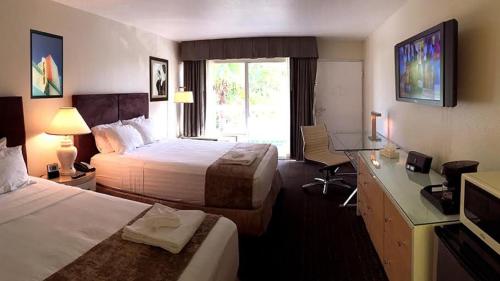 a hotel room with two beds and a desk at Floridian Hotel in Homestead