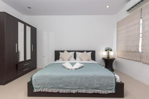 una camera da letto con un letto grande con due cuscini sopra di Peaceful House in Rawai, Phuket a Phuket