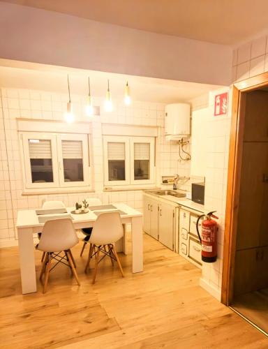 a kitchen with a white table and chairs in it at Apartamento rural in Pravia