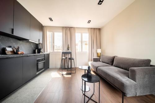 un salon avec un canapé et une cuisine dans l'établissement Stardust Comédie - Élégant Confort & Terrasse, à Montpellier