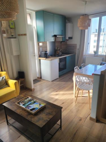 un salon avec une table et une cuisine dans l'établissement L'Echappée Mer, à Fécamp