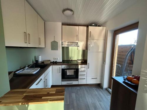 a kitchen with white cabinets and a stove top oven at Fischbacher Waldidyll in Bad Schwalbach