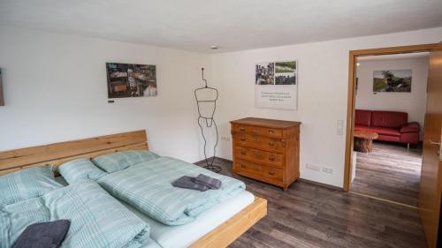 a bedroom with a bed and a dresser and a red couch at Ferienwohnung Radhaus, Todtnau, 3 Schlafzimmer in Todtnau