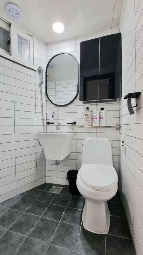 a bathroom with a toilet and a sink and a mirror at Petit Mejong in Seoul
