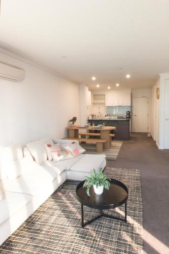 a living room with a white couch and a table at Ultimate Southbank Getaway with Free Parking in Melbourne