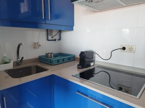 a kitchen with blue cabinets and a sink at Cambados Apartamento VUT-PO-TU986D in Cambados