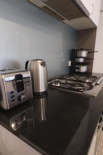 a kitchen with a stove with a coffee maker on it at Ultimate Southbank Getaway with Free Parking in Melbourne