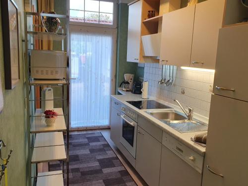 a kitchen with white cabinets and a sink at Ferienwohnung 1, unten in Bad Wilsnack