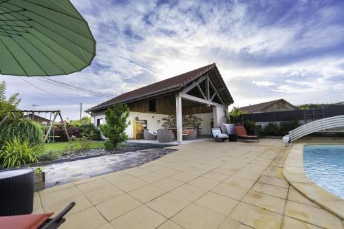 un patio avec une piscine et une maison dans l'établissement Appartement cosy et chaleureux 6 personnes, à La Baffe