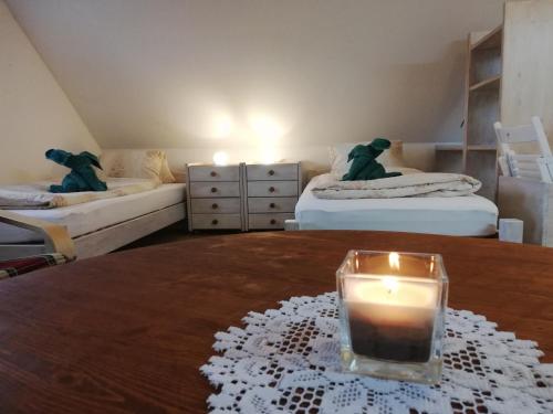 een kamer met twee bedden en een kaars op een tafel bij Statek u Badyho in Dolní Třebonín