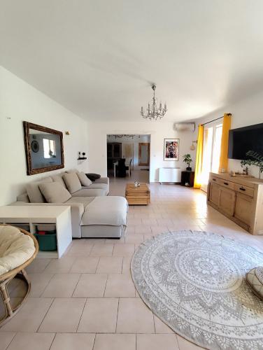 un salon avec un canapé et une télévision dans l'établissement Villa Piscine intérieure et forêt, à Saint-Alexandre