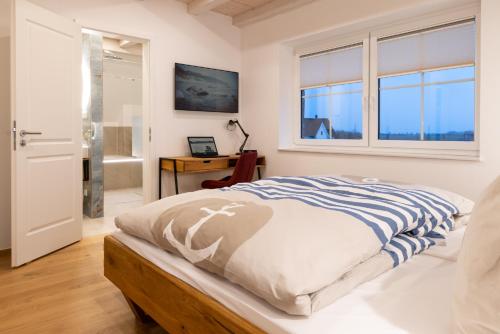 Un dormitorio con una cama y una ventana y un escritorio. en Reethaus Nordlicht, en Dranske