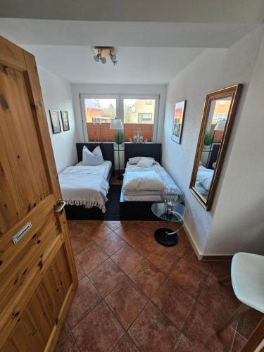 ein kleines Zimmer mit zwei Betten und einem Spiegel in der Unterkunft Kapitänshaus - Zickenstube in Barth