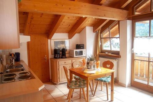 a kitchen with a table and chairs in a room at Gänseblümchen -805- in Mittenwald