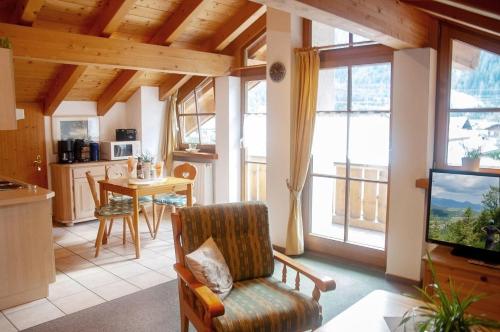 a living room with a couch and a tv and some windows at Gänseblümchen -805- in Mittenwald