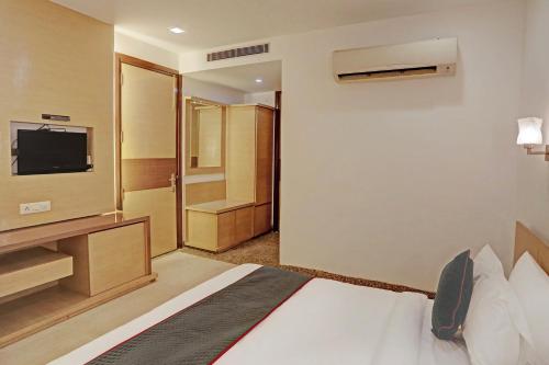 a hotel room with a bed and a television at Townhouse RELAX SUITS A BOUTIQUE HOTEL VASUNDHARA in Ghaziabad