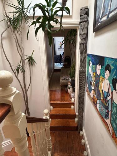 a hallway with stairs with a painting on the wall at Sydney Harbour Designer Terrace Guest Wing in Sydney