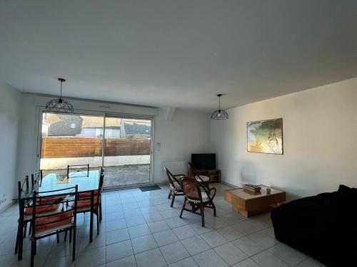 un salon avec une table bleue et des chaises dans l'établissement Maison plain pied a 10 mn de la plage en campagne, à Saint-Malo