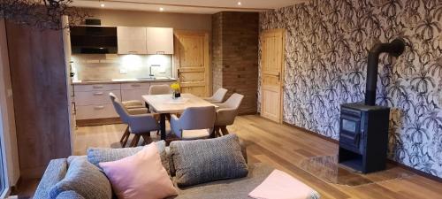 a living room with a table and a stove at Ferienhaus zum Holzmichel in Neinstedt