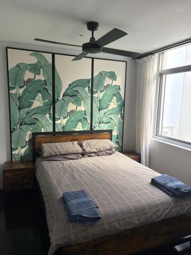 a bedroom with a bed with a large painting on the wall at A modern two bedroom apartment! Quiet, secure and 1 minute walk to Bondi Beach! in Sydney