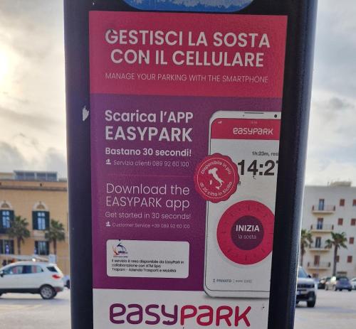 a sign on a parking meter in a parking lot at 32Venti Comfort Apartments Trapani in Trapani
