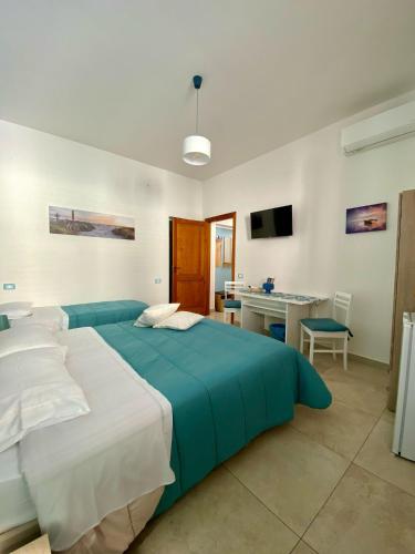 a bedroom with a large blue bed and a desk at La Capinera Holidays in Santa Flavia
