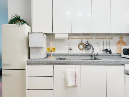 a white kitchen with a sink and a refrigerator at JAJA Haenggung, SuwonㅣNext to Hwaseong FortressㅣCozy Korean VibeㅣComfortable & Well-keptㅣUp to 8 guestsㅣFree Parkingㅣ2-night minimumㅣLoved by many guests in Suwon