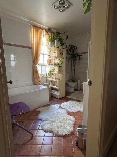 a bathroom with a tub and a white rug on the floor at Sydney Harbour Designer Terrace Guest Wing in Sydney