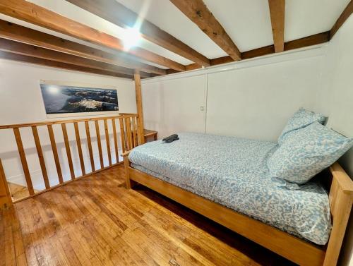 une chambre avec un lit et un parquet dans l'établissement Cozy Studio in Championnet - Quiet & Central Location, à Grenoble