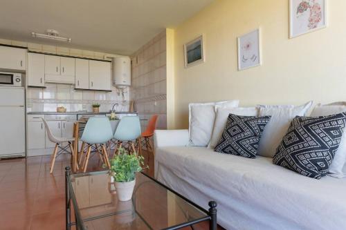 Una sala de estar con un sofá blanco y una cocina. en Fgdr402c arena, en San Vicente de la Barquera