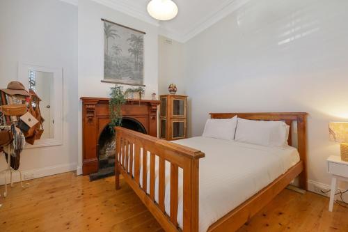 a bedroom with a wooden bed and a fireplace at 3 bdrm house in CBD sleeps 6 in Warrnambool