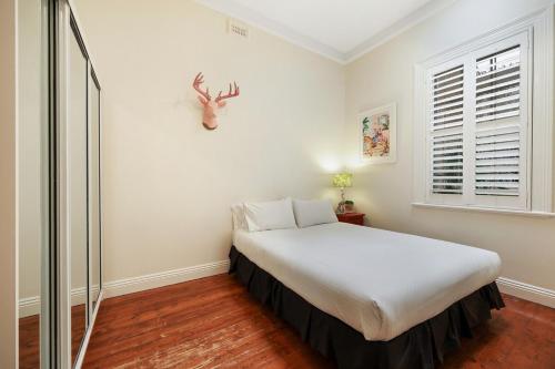 a bedroom with a bed in a room with a window at 3 bdrm house in CBD sleeps 6 in Warrnambool
