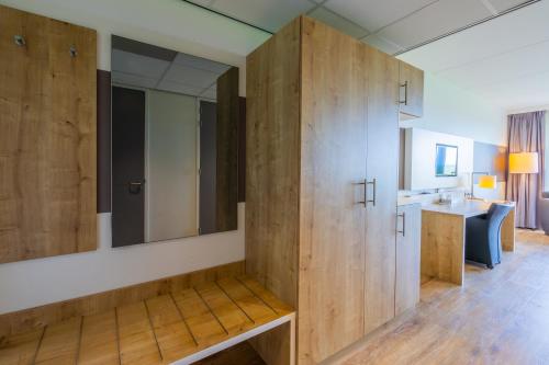 a bathroom with a large wooden cabinet and a sink at Best Western Plus Hotel Restaurant Aduard in Aduard