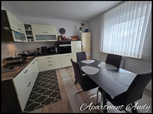 a kitchen with a table and chairs in a kitchen at Apartment Andy in Medvode