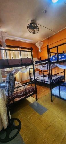 a dorm room with three bunk beds in it at We Travel Hostel in Moshi