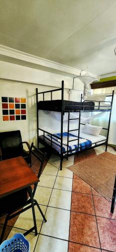 a room with two bunk beds and a table at We Travel Hostel in Moshi