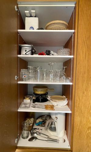 a cupboard filled with lots of dishes and glasses at Haus Stadel Wohnung Nr. 36 in Albinen