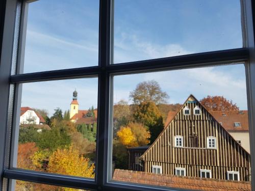 a window with a view of a building at Fewo Niedere Mühlwiese in Großschönau