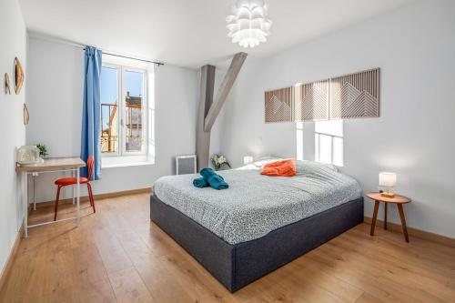 a bedroom with a bed and a table and two windows at Charming T4 - Cosy Air Conditioning in Béziers