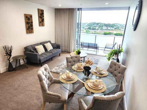 a living room with a glass table and chairs at Spacious River View Escape with Free Secure Park - 2BR, 2BA and Sofa Bed in Brisbane